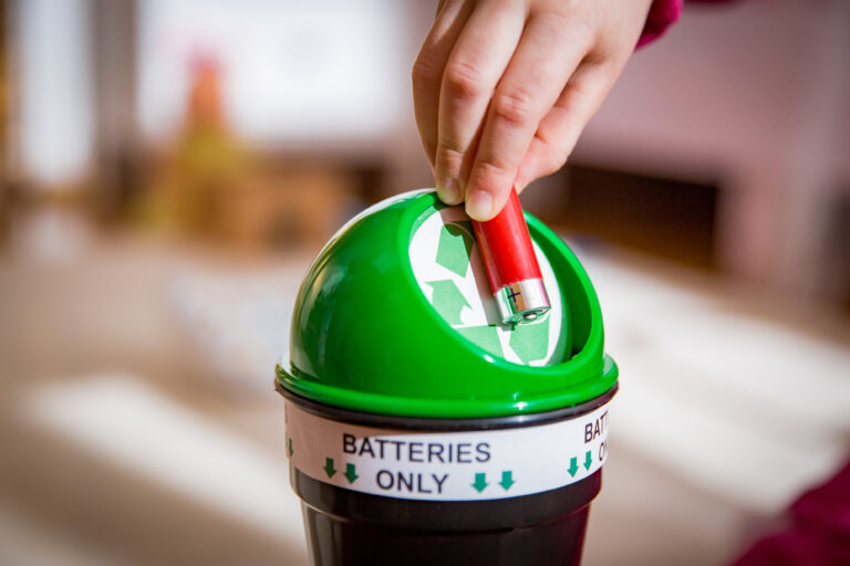 putting used batteries into recycling box